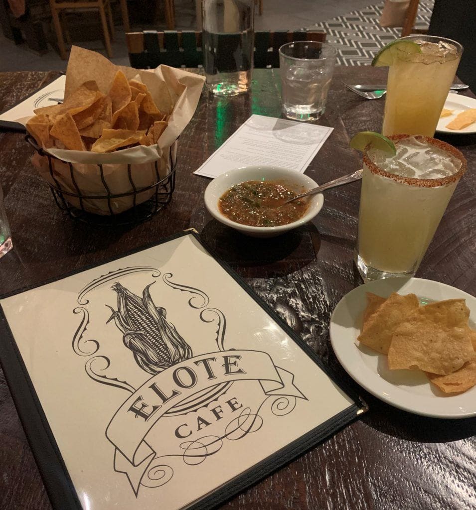 Restaurant table loaded with food and menu from Elote in Sedona