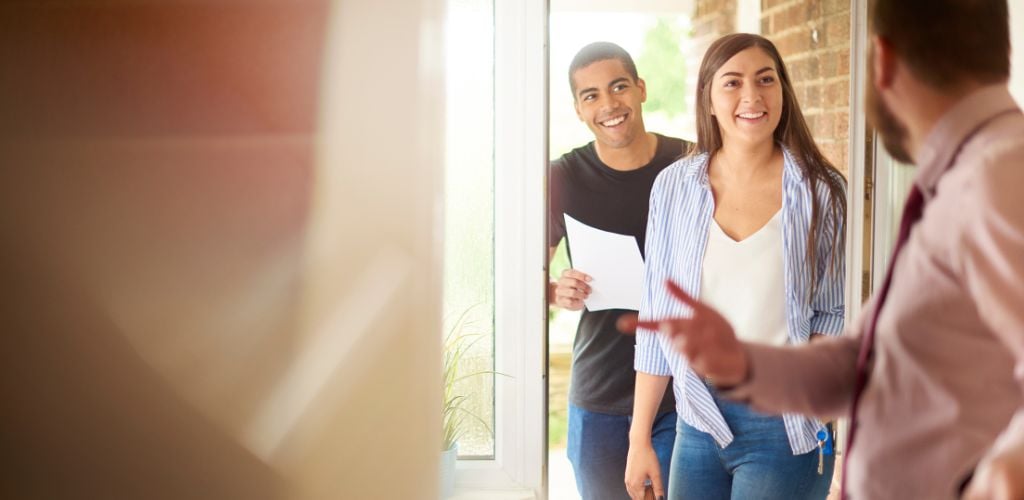 A couple is guided through a property viewing.