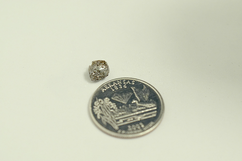 Comparison of the diamond to an Arkansas quarter.