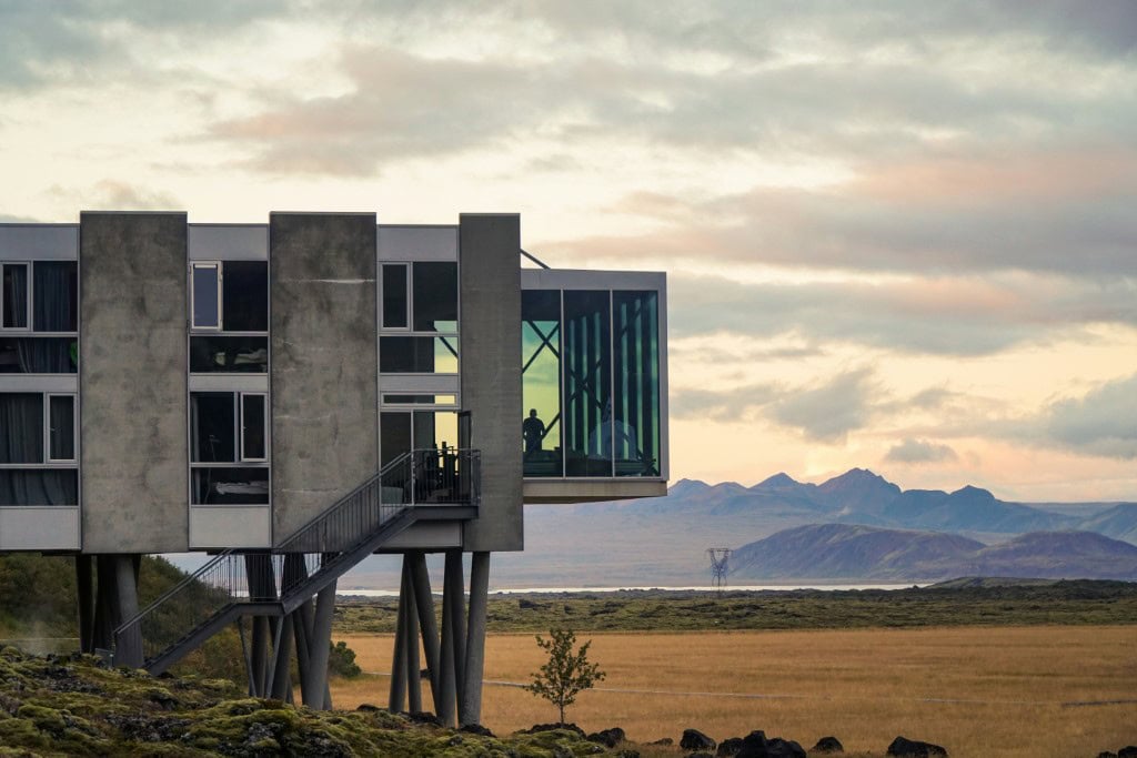 Modern architectural design of the ION Adventure Hotel, elevated on pillars, with large glass windows offering panoramic views of Iceland's landscape.