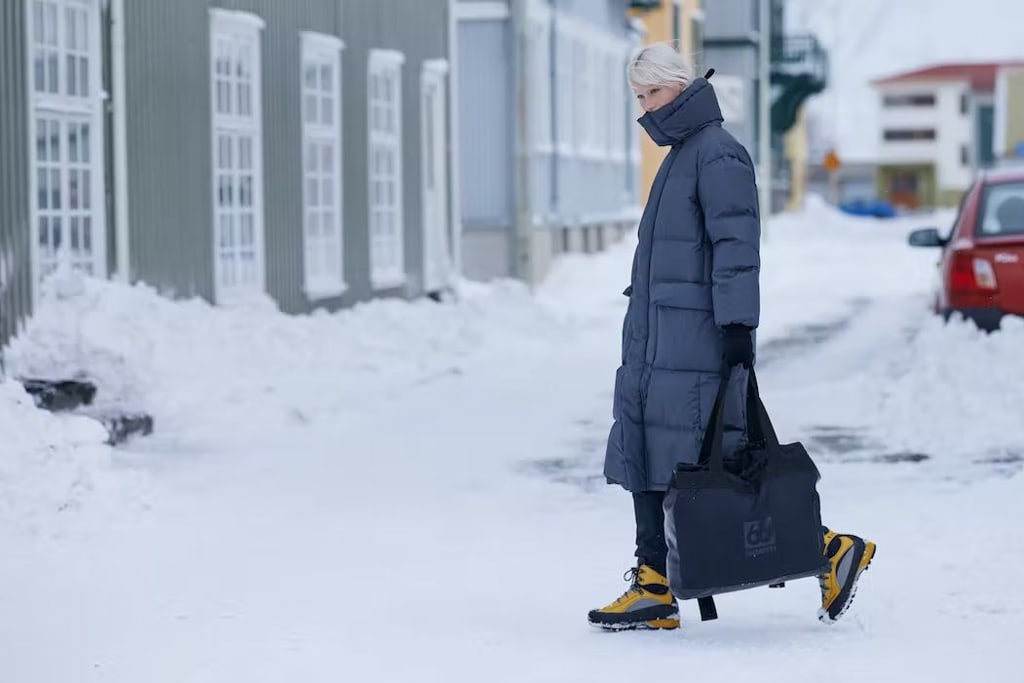 Local woman walking on the street in Reykjavík wearing a large winter parka