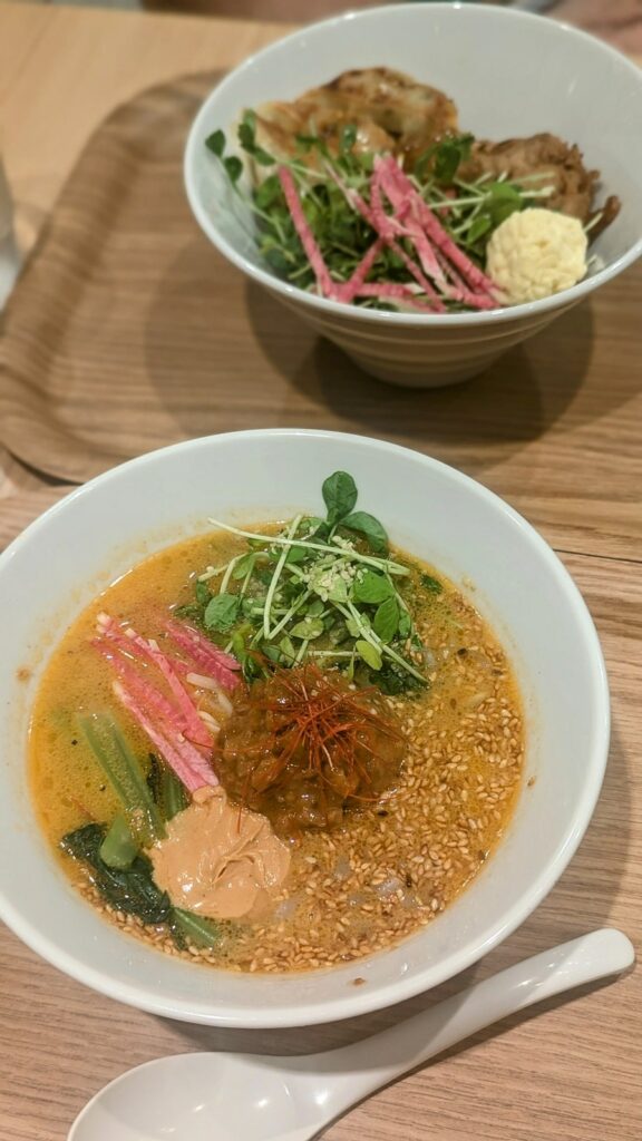 a bowl of vegan golden sesame ramen topped with minced soy meat and tahini at Ts Tantan