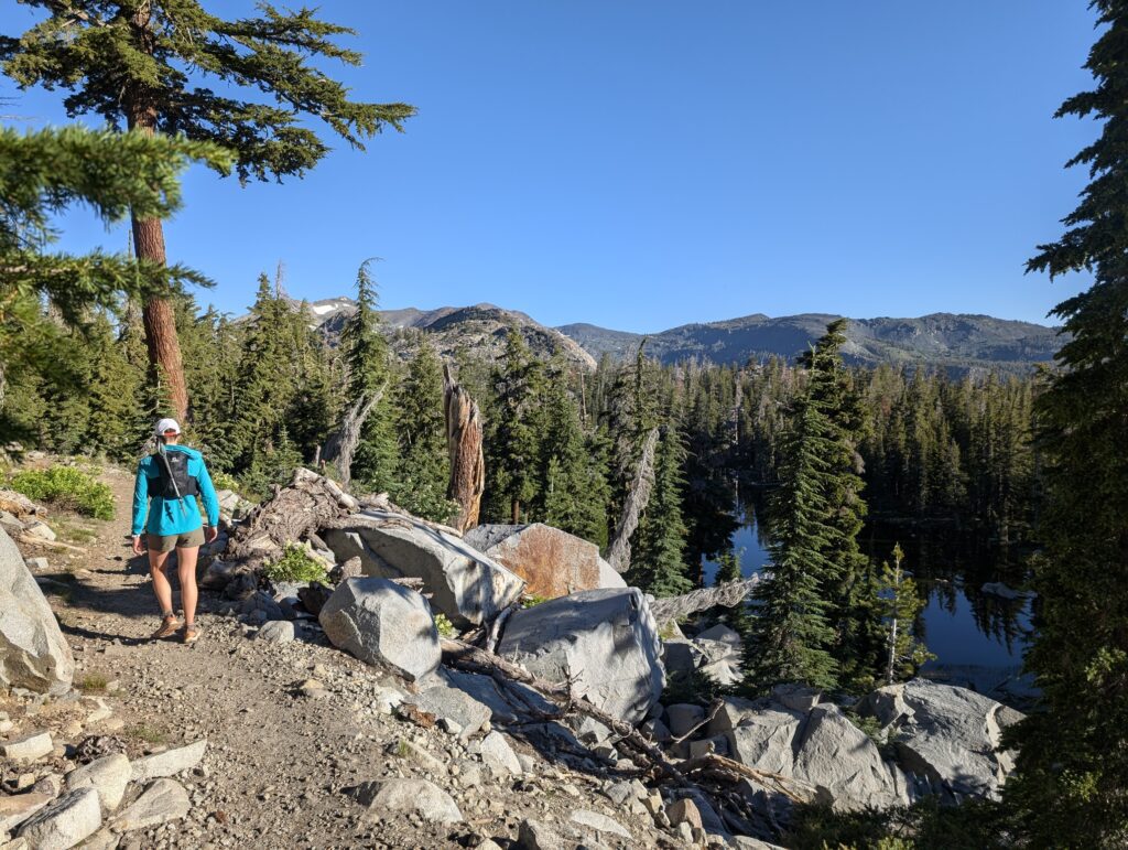 A woman hiking on the PCT en route to Aloha Lake in California's Desolation Wilderness.