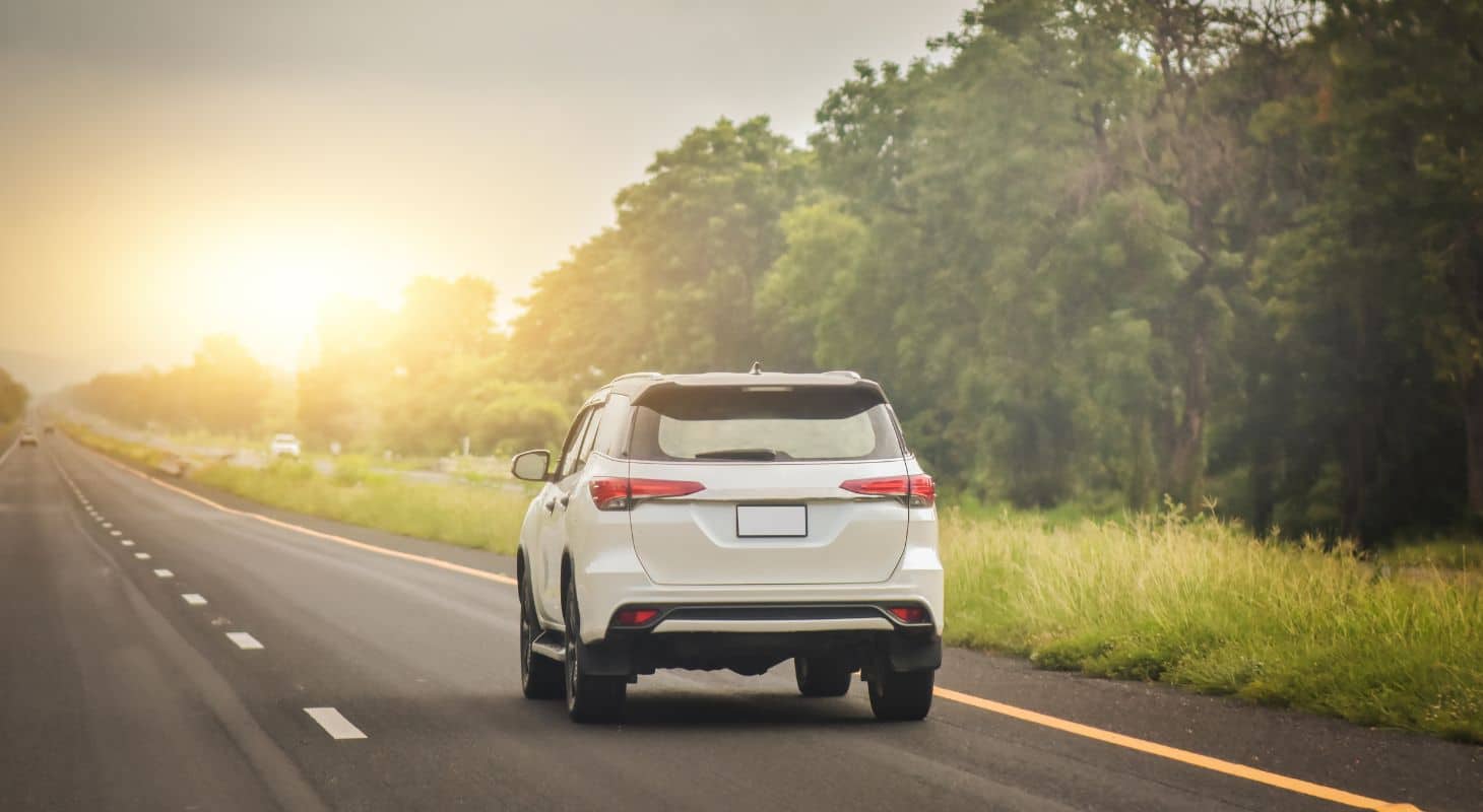 Car driving on a highway toward the rising sun