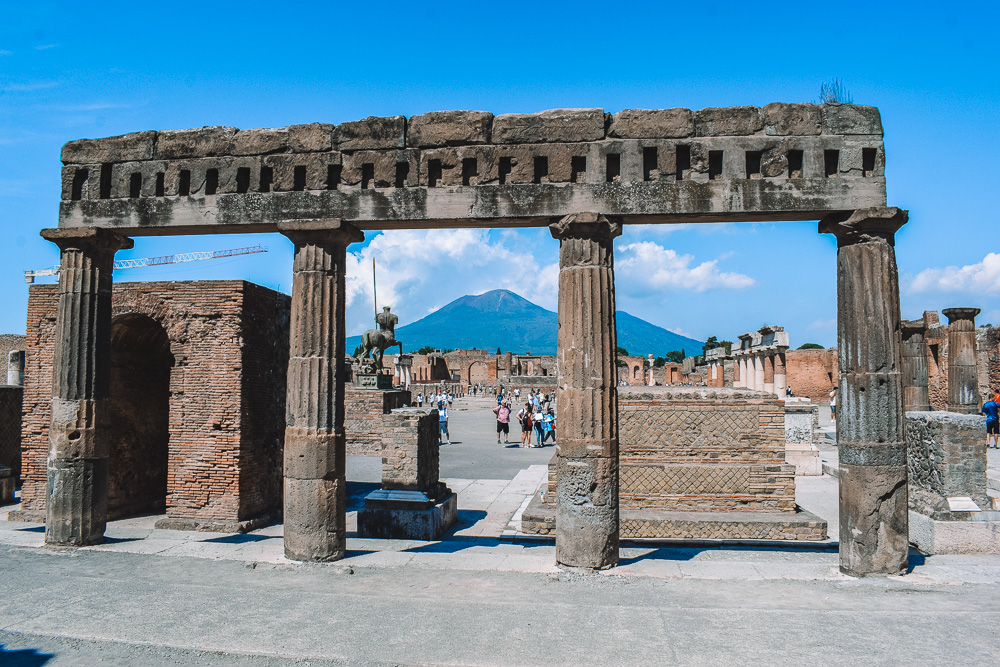 Columns of the Foro di Pompeii framing Mount Vesuvius in the background