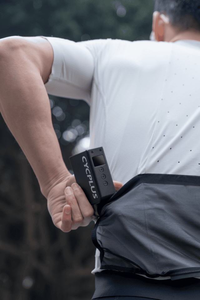 man putting small bike pump in shirt pocket