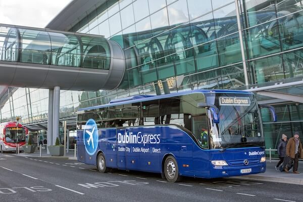 A bus parked outside an airport terminal, a transport option from Ireland's airports